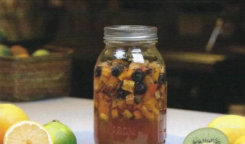 Mix de seis frutas en almíbar, embotellado, junto a kiwi y limón cortados