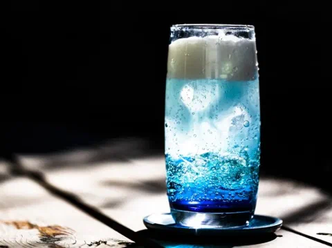 Ade de arena blanca, en capas de azul y verde con crema de coco encima