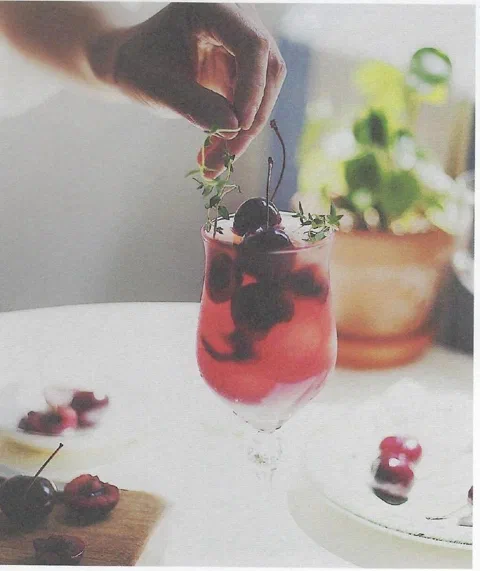 Ade de cereza, con cereza fresca y tomillo de decoración