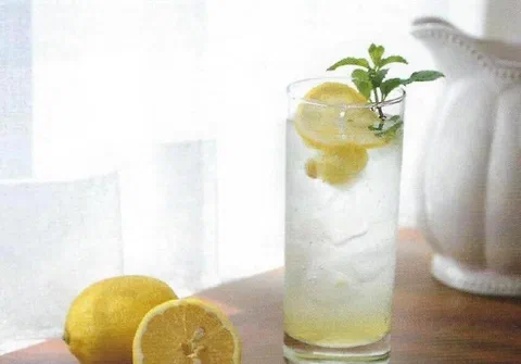 Ade de jengibre y limón, con rodajas de limón y menta de decoración