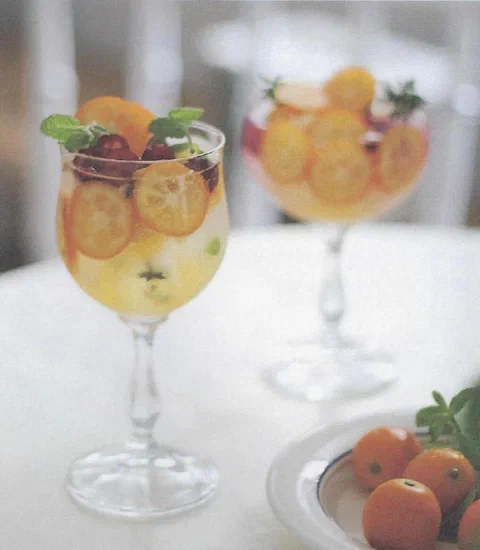 Ade de kumquat, con rodajas de cítrico y menta de decoración