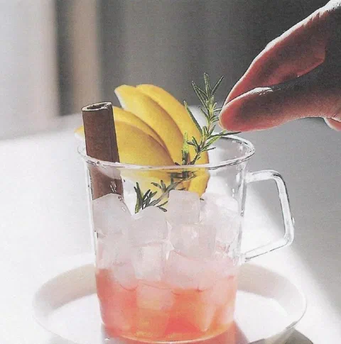 Ade de manzana y canela, con rama de canela, rodajas de manzana y romero de decoración