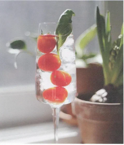 Ade de tomate y albahaca, con tomates cherry ensartados y una hoja de albahaca