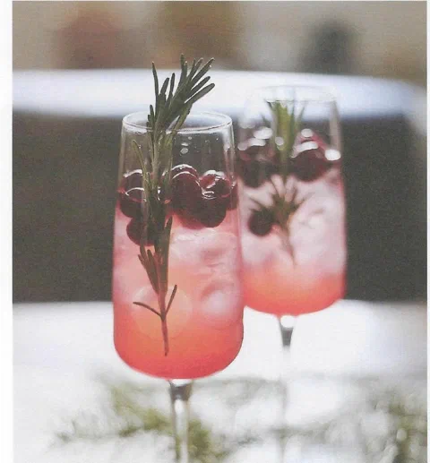 Ponche de Navidad, en copa, con cranberries y romero de decoración