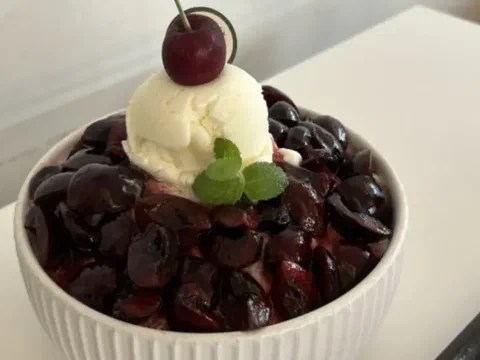 Bingsu de cereza, coronado con helado y una cereza con tallo