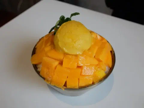 Bingsu de mango y menta, con trozos de mango y menta fresca encima