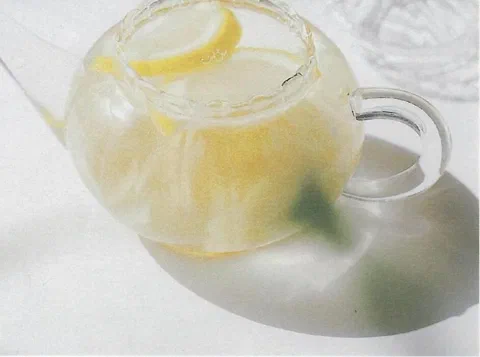 Té de limón y jengibre, servido tibio en una tetera de vidrio