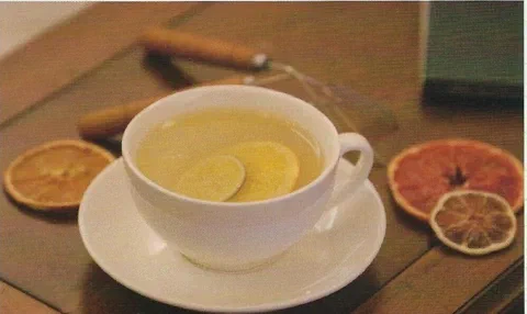 Té de mandarina y naranja, servido en una taza con fruta cítrica deshidratada de decoración