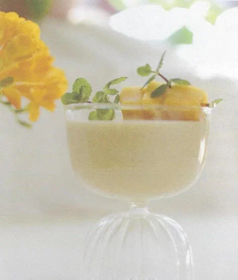 Lassi de mango, con cubos de mango y hierbas de decoración