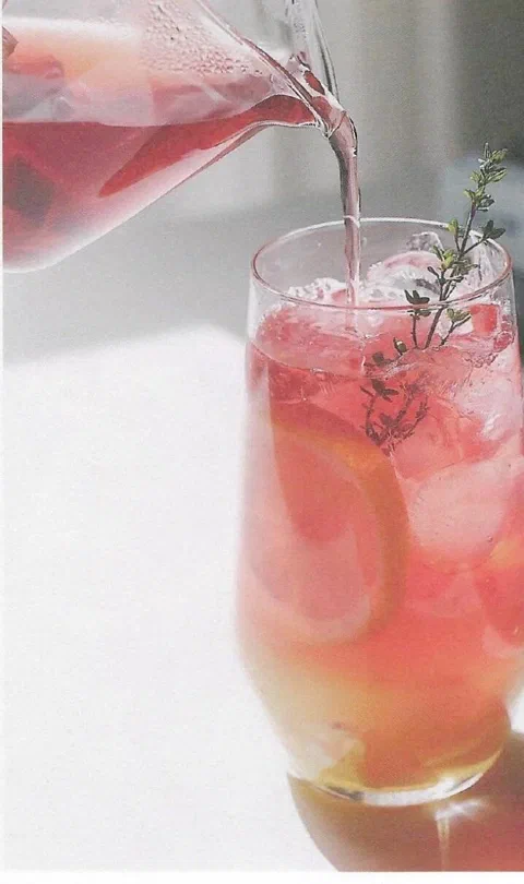 Ade de limón y jengibre, con rodaja de limón y hierbas de decoración