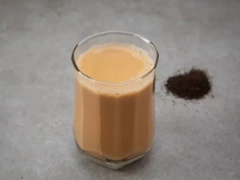 Milk tea oscuro, con hojas de té negro al costado