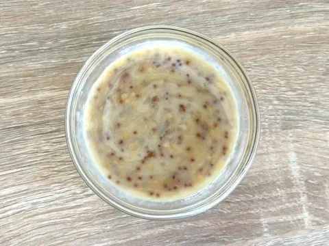 Aderezo de miel y mostaza a la antigua, textura granulada en un bowl de vidrio