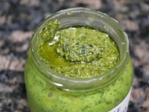 Pesto de albahaca en un frasco de vidrio, base del aderezo de pesto