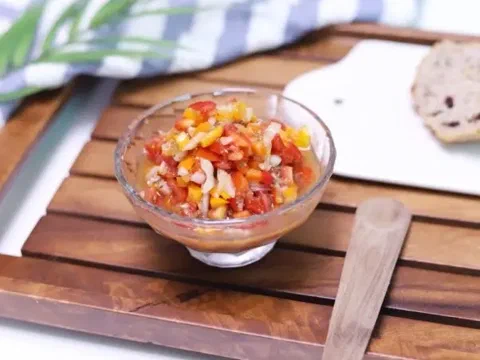 Aderezo tipo salsa con cebolla, ají limo y pimiento picados en un bowl de vidrio