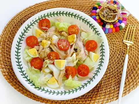 Ensalada de pollo y huevo sobre lechuga, con tomate cherry
