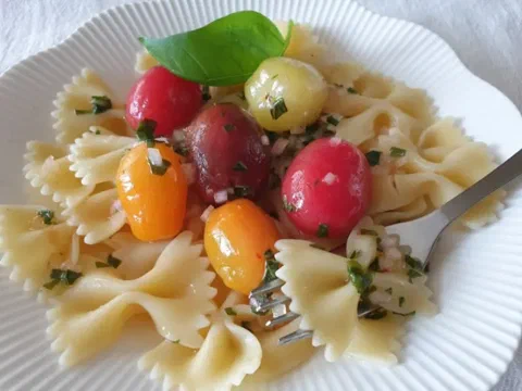 Farfalle caprese con tomates cherry de colores y albahaca fresca