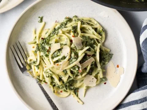 Tagliatelle de choclo y espinaca, con láminas de queso encima