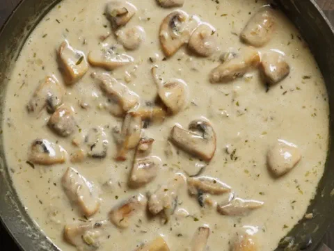 Pechuga de pollo fricasé, en una salsa cremosa con champiñones y tocino