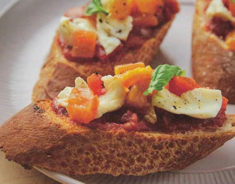 Bruschetta de pimientos asados con bocconcini, sobre baguette con salsa de tomate