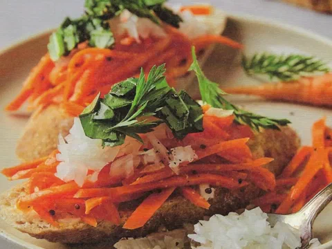 Sándwiches abiertos de pan de centeno con zanahoria rapé, cebolla y kale