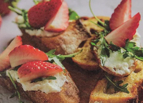 Sándwiches abiertos de baguette tostada con ricotta, arúgula y fresas frescas