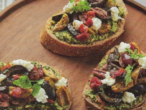 Untable de aceitunas variadas y tomate seco sobre pan con pesto de albahaca