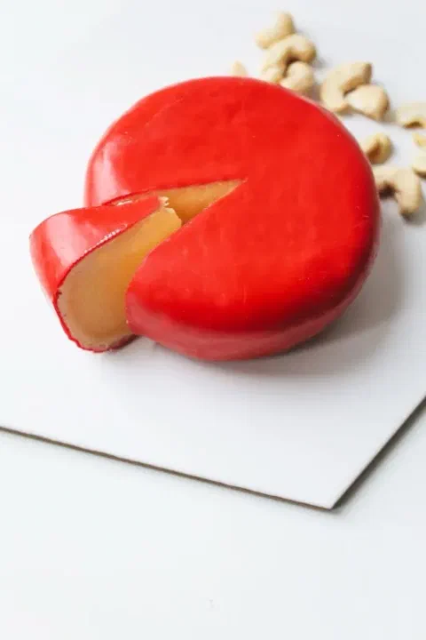 Queso edam con su característica cáscara roja, cortado