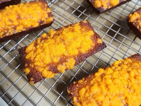 Financiers de crumble de queso cheddar, con la superficie anaranjada y crocante