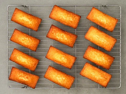 Financiers dorados en fila sobre una rejilla