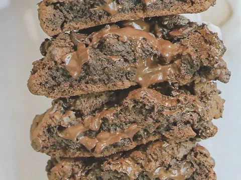 Galletas clásicas de chocolate apiladas, con el chocolate derretido asomando entre las capas
