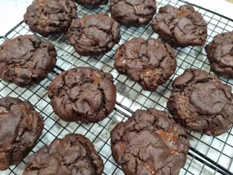Galletas de chocolate Valrhona recién horneadas, con la superficie agrietada y el chocolate derretido asomando