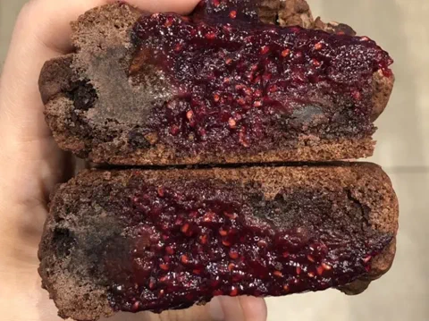 Galletas de frambuesa y chocolate, con la compota de frambuesa asomando en el centro