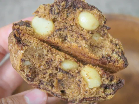 Galleta de macadamia cortada, mostrando la macadamia entera dentro de una masa clara
