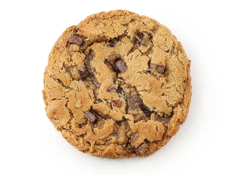 Galleta javachip de nuez, mostrando los trozos de chocolate y nuez tostada en el corte