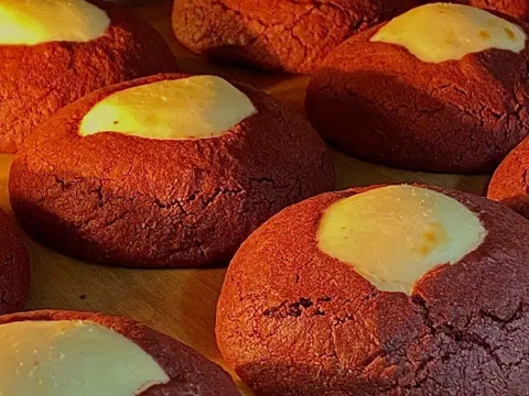 Galleta red velvet partida, mostrando el centro de queso crema escondido adentro