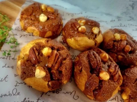 Galletas de caramelo salado, con avellana y pecana sobre la superficie brillante de caramelo