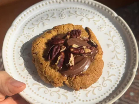 Galleta de chocolate y pecana con chocolate derretido y pecanas enteras encima