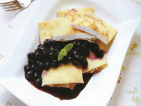 Crepe doblado en cuadrado, relleno de crema y arándanos