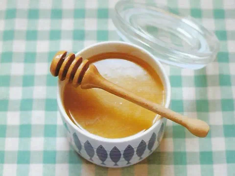 Frasco de salsa butterscotch con un cucharón de miel
