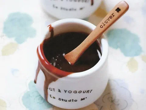 Salsa de chocolate en un pote, con una cuchara de madera