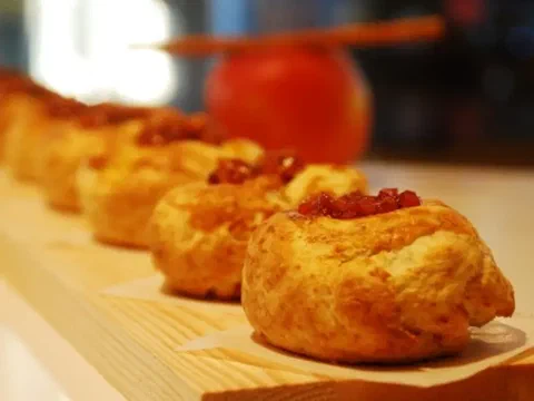Scones de manzana y canela en fila, con compota de manzana visible arriba