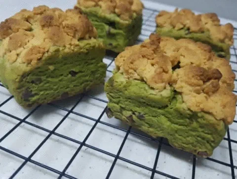 Scones de matcha y chocolate partidos, mostrando el interior verde con chips de chocolate