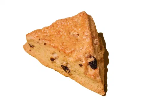 Scone de pasas partido a la mitad, mostrando las pasas repartidas por dentro