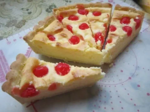 Tarta de cereza y almendra cortada en porciones, mostrando la crema horneada con cerezas