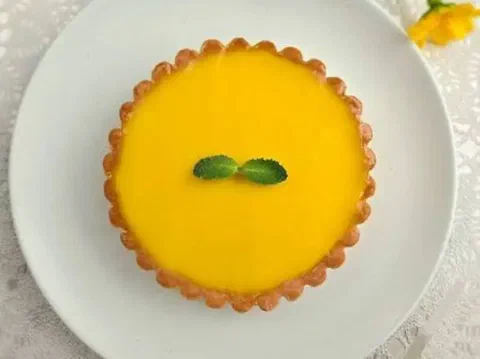 Tartaleta de limón individual, con la superficie lisa color amarillo brillante