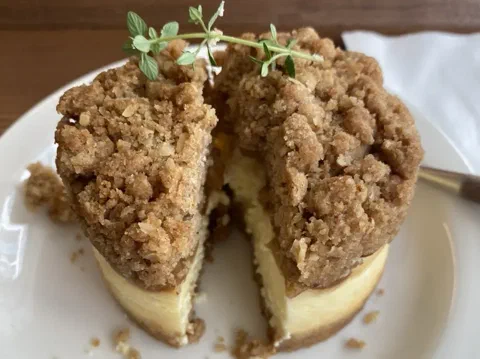 Cheesecake de manzana y crumble cortado, mostrando la compota de manzana entre el relleno y el crumble