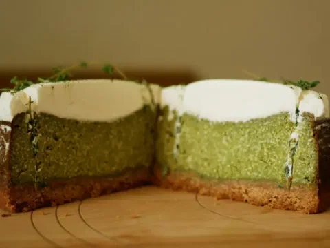 Cheesecake de matcha cortado, mostrando las capas de base, relleno verde y crema