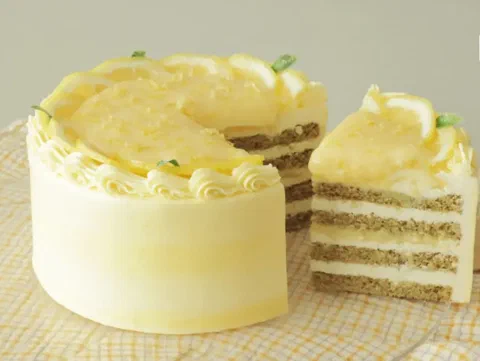 Torta de crema de limón en 3 capas, decorada con rodajas de limón y ralladura