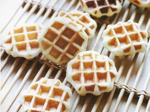 Waffles de Lieja recién horneados, dorados y crocantes, sobre una rejilla de bambú