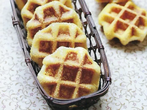 Waffles de Lieja de maíz cubiertos de grits gruesos, en un canasto